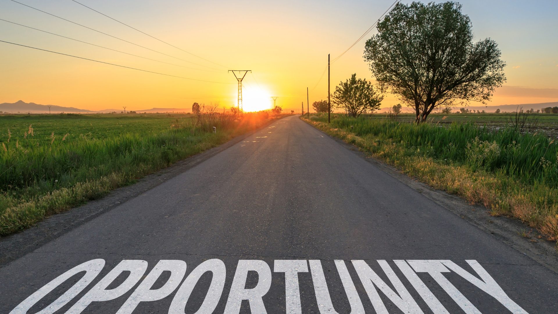 An open road stretching toward a sunrise