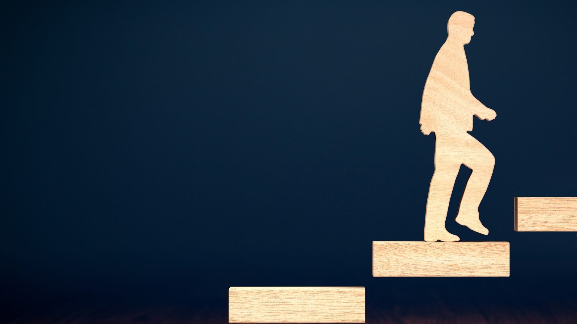 A wooden figure climbing block steps upward, representing a staged process